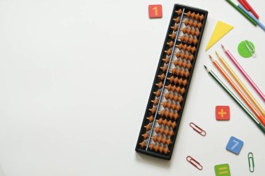 Mental arithmetic and Mathematics concept: colorful pens and pencils, numbers, abacus scores on white background, copy space