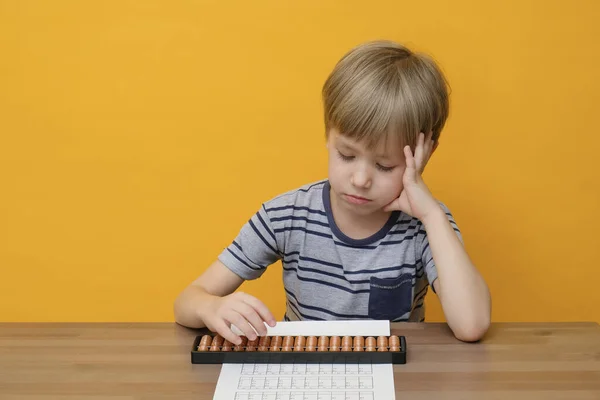 Kleine jongen die eenvoudige wiskunde oefeningen doet met abacus scores. Geestelijke rekenkunde. — Stockfoto