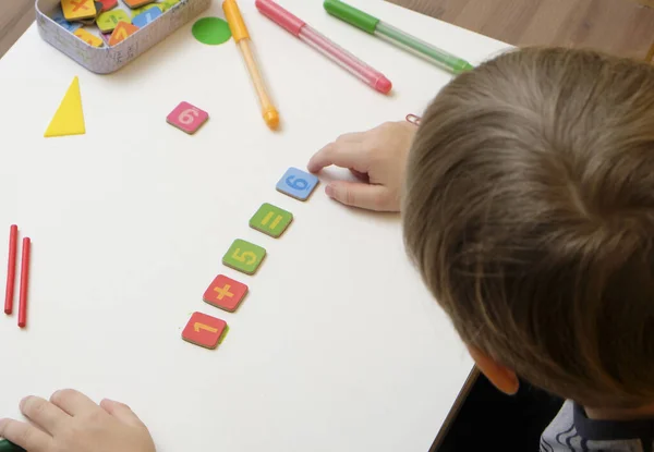 Kleine jongen kind voorbereiding voor basisschool doen eenvoudige wiskunde oefeningen. — Stockfoto