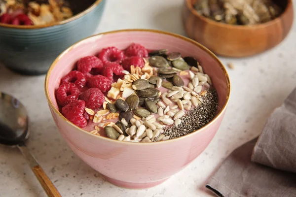 Healthy food - smoothie bowl topped with raspberries, granola, seeds and chia. Closeup view — Stock Photo, Image