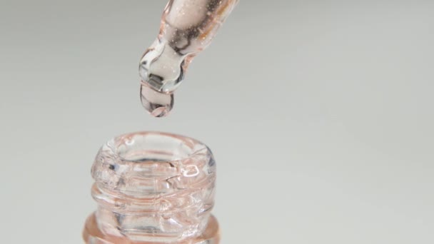 Gota de suero hidratante, aceite, vitamina para la piel de la cara sobre fondo blanco. Cuidado de la piel Esencia, macro — Vídeo de stock