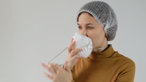 Frau mit Einwegbecher und Filtermaske für Umweltverschmutzung und Personenschutz auf weißem Hintergrund. — Stockvideo