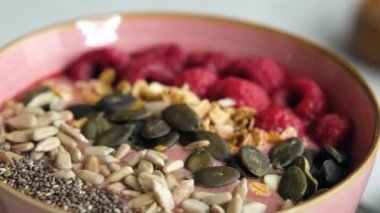 Sağlıklı organik ahududu Smoothie kasesi Granola, tohumlar ve chia, yakın çekim. Vejetaryen kahvaltısı