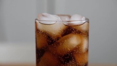 Pouring Soda with ice cubes close-up