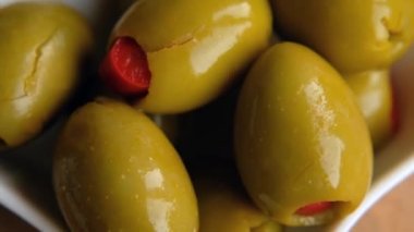 Green Olives Stuffed with Red Bell Peppers rotating, close up. Macro