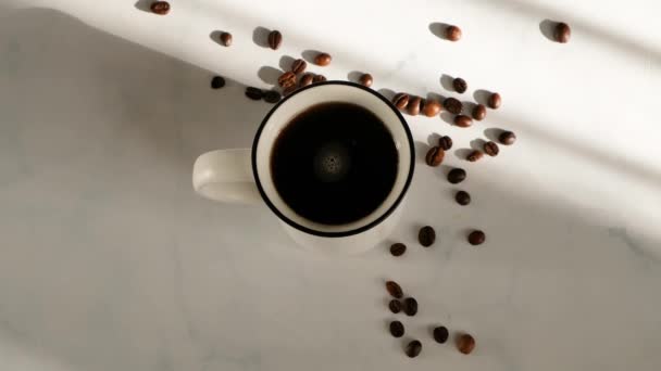 Femme main brassant café dans une tasse sur une table en marbre blanc avec une belle lumière, vue sur le dessus 