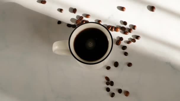 Vrouwen hand roeren koffie in een kopje op witte marmeren tafel met mooi licht, bovenaanzicht — Stockvideo