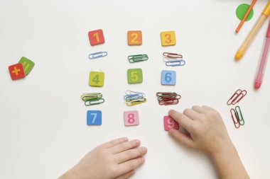 Küçük çocuk basit matematik egzersizleri yaparak ilkokula hazırlanıyor. Yukarıdan görüntüle