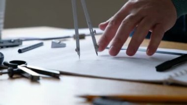 Mimarlar masası: çizimler, pusula, cetvel ve diğer çizim araçları. Mühendis çizimlerle çalışır, yakın plan..