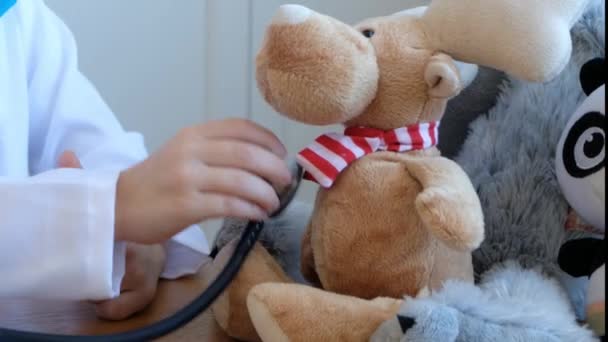 Menino bonito brincando médico com estetoscópio e seus brinquedos — Vídeo de Stock