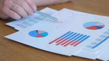 Ofiste iş diyagramıyla çalışan adam, kapat.