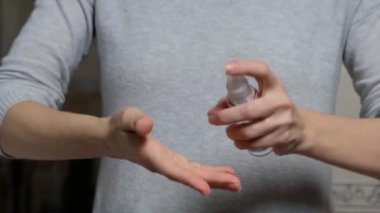 Bakterilerden ve koronavirüsten korunmak için ellere antiseptik sprey sıkan bir kız. Doğru salgın önlemleri. Temiz eller.