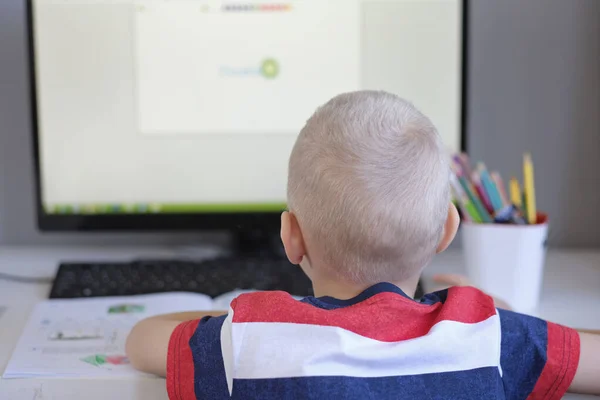 Distansutbildning på nätet. Oigenkännlig kaukasiska pojke gör läxor på nätet medan karantän av epidemi corona virus — Stockfoto