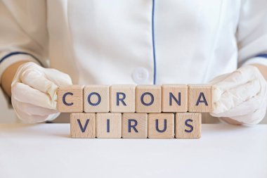 Coronavirus, doktorların elindeki tahta küplere yazılmış bir yazı. Covid-19 Solunum Sendromu Coronavirüs.