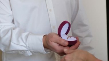 Nişan yüzüğüyle pembe kutu tutan adam, aşk dolu kadına evlenme teklif et, kapat.