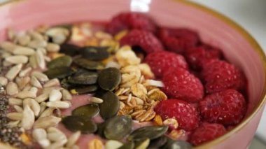 Sağlıklı organik ahududu Smoothie kasesi Granola, tohumlar ve chia, yakın çekim. Vejetaryen kahvaltısı