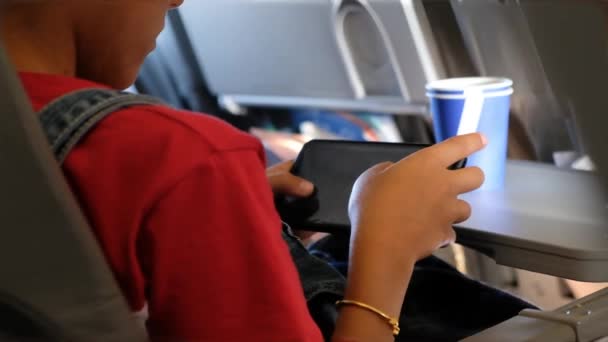 비행기에서 스마트폰으로 놀고 있는 여자 애가 문을 닫고 — 비디오