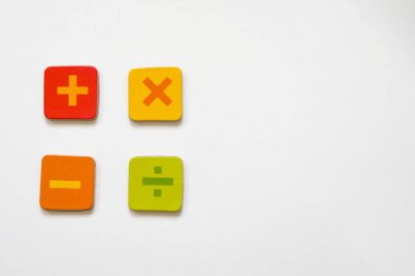 Matematik arkaplanı artı, eksi, beyaz masa üzerindeki bölme işaretleri, yakın çekim. Matematik konsepti. Üst görünüm