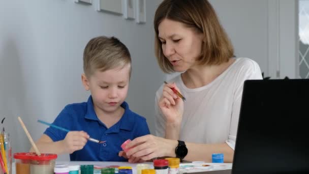 Kleiner Junge lernt Online-Zeichnen mit seiner Mutter über das Internet mit Blick auf Laptop, Fernunterricht, — Stockvideo