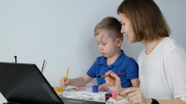 Kleiner Junge lernt Online-Zeichnen mit seiner Mutter über das Internet mit Blick auf Laptop, Fernunterricht, — Stockvideo