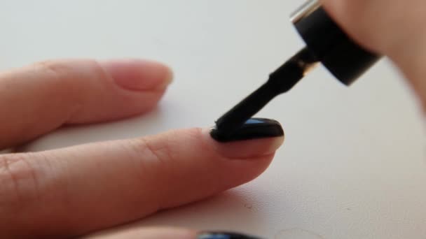 Vrouw die zwarte nagellak aanbrengt, close up — Stockvideo