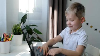 Bilgisayar bilgisayarı kullanarak öğrenen şirin bir anaokulu çocuğu. Uzaktan eğitim kavramı.