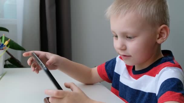 Lindo niño de la escuela aprendiendo o jugando en la computadora tableta PC, concepto de educación a distancia . — Vídeos de Stock