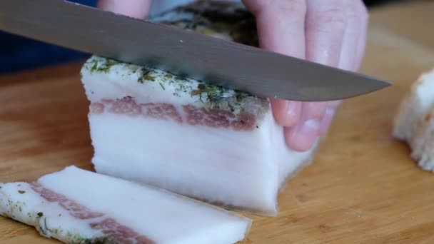Chef corta pedaços de bacon por faca afiada na tábua de madeira, cozinhando gordura — Vídeo de Stock