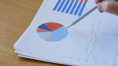 Merkez ofisteki diyagramlara bakan yakın odaklı iş adamı.