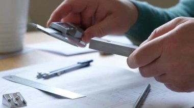 Mühendisler masası: çizimler, ışın pusulaları, cetvel ve diğer çizim araçları. Mühendis çizimlerle çalışır, yakın plan..
