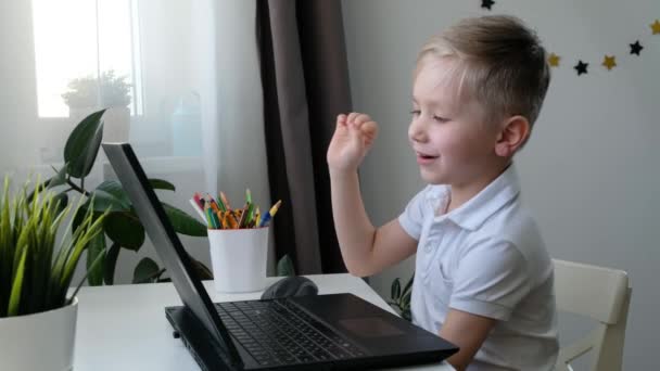 Roztomilý malý školáček dítě mluvení s někým přes hlasový hovor, učení na počítači, distanční vzdělávání koncept — Stock video