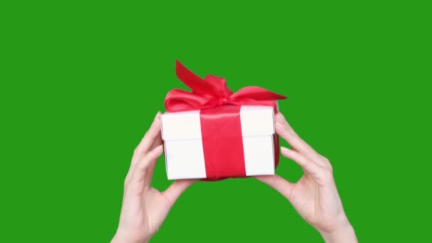 女人的手拿着一个绿色彩色钥匙背景的礼品盒。情人节、国际妇女日、生日、假日概念 — 图库视频影像