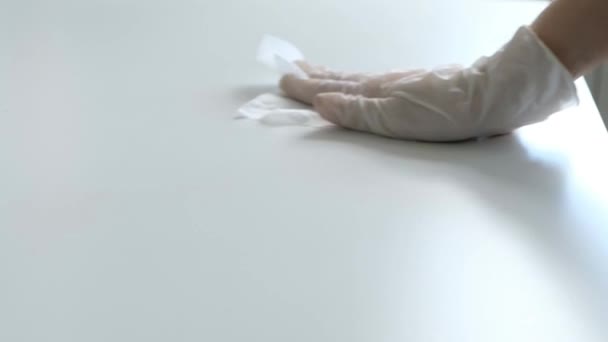 Mano en la tabla médica blanca del paño del guante con la servilleta, tratamiento antiséptico contra el virus de la corona, primer plano — Vídeos de Stock