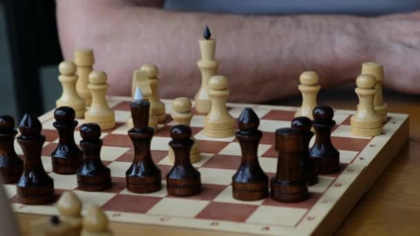 Мальчик играет в шахматы со своим дедушкой, шахматы крупным планом — стоковое видео