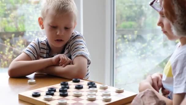 Little boy child play checkers with grandfather — Stock Video