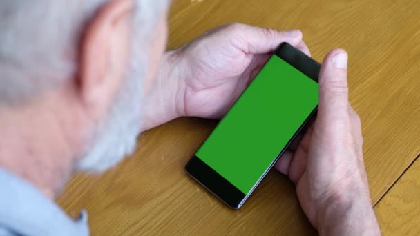 Tangan senior dengan smartphone hijau layar kunci kroma, menutup — Stok Video