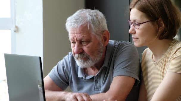 Glad äldre far farfar och vuxen dotter, hjälpa honom med datorn — Stockvideo