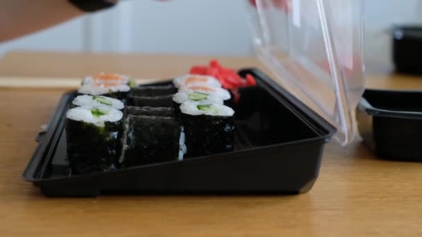 Womans mão tomando rolos de sushi de caixa de plástico, serviço de entrega de comida japonesa — Vídeo de Stock