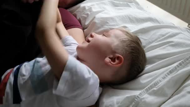 Lycklig far har roligt på en säng med sitt son barn, skrattar. Utsikt ovanifrån — Stockvideo