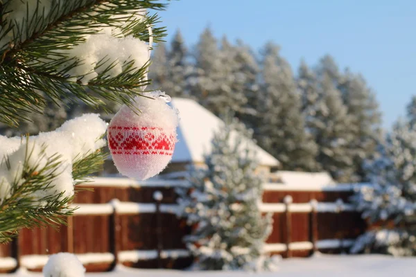 Christmas toy hanging on the pine branch on the background of a winter landscape. — Stock Photo, Image