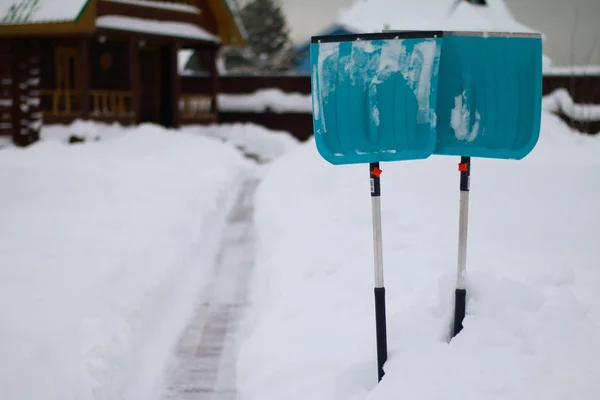Two shovels cleaning the snow from the tracks are in a snowdrift. — Stock Photo, Image