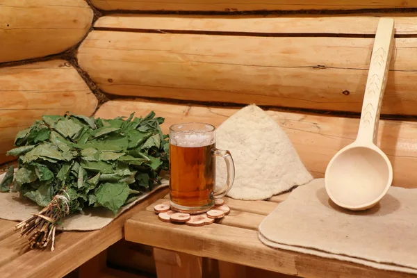 Rus banyoda bankta banyo mutfak eşyaları ve bir bardak light bira vardır.