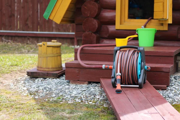 Haspel met een slang voor de put in de tuin staan. — Stockfoto