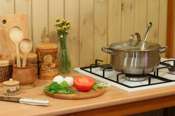 Свіжі овочі та зелень на кухонному столі під час приготування їжі . — стокове фото