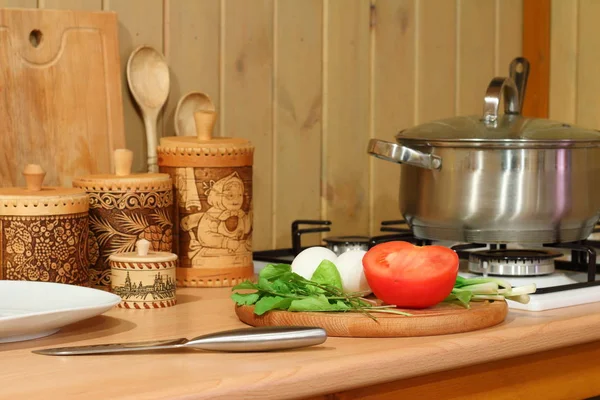 Свіжі овочі та зелень на кухонному столі під час приготування їжі . — стокове фото