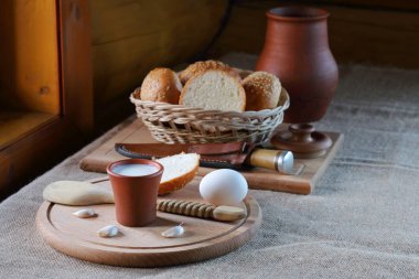 Bir fincan süt ve ekmek ile bir hasır sepet. 