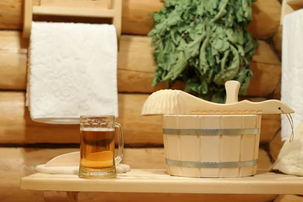 A mug of light beer on a bench in the bath.