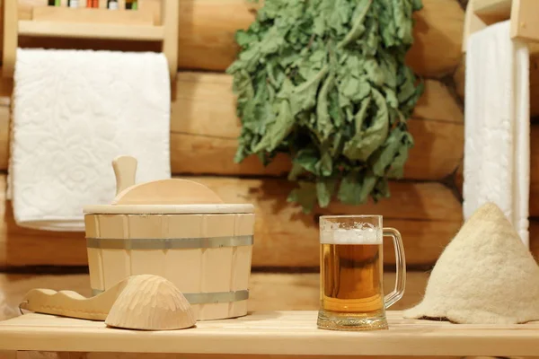 Une tasse de bière légère sur un banc dans le bain . — Photo