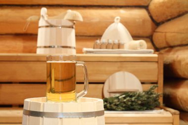 Banyo aksesuarları ve arka plan üzerinde saunada bir varil üzerinde light bira kupa.