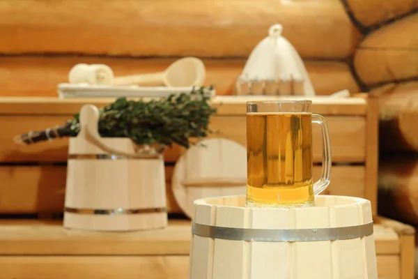 Banyo aksesuarları ve arka plan üzerinde saunada bir varil üzerinde light bira kupa.